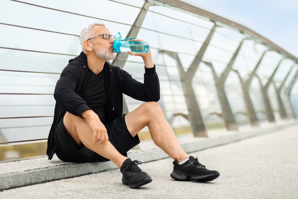 deportista hidratandose para prevenir calambres musculares